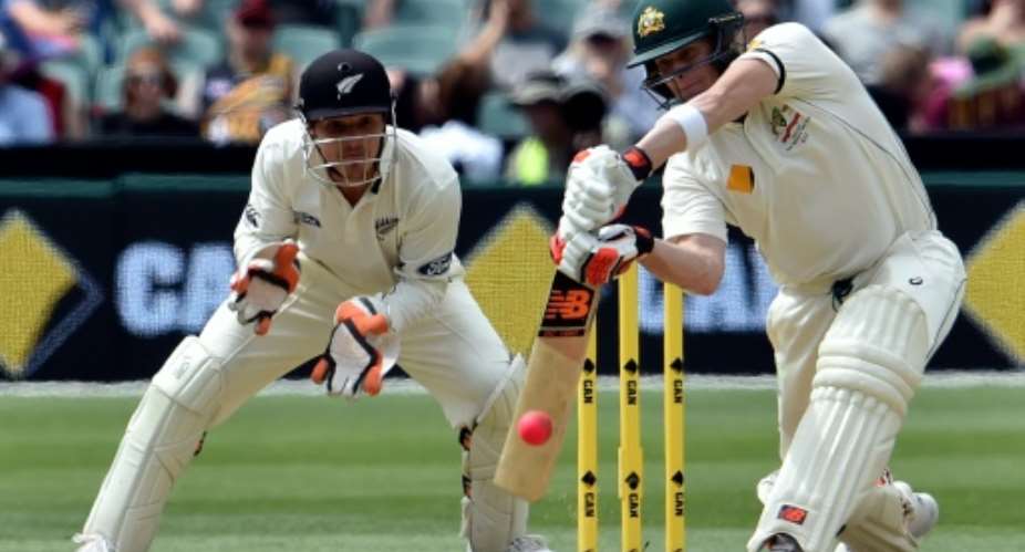 Australia captain Steve Smith plays a shot to reach 50 runs next to New Zealands wicketkeeper BJ Watling during the second day of the day-night Test at the Adelaide Oval on November 28, 2015.  By Saeed Khan (AFP/File)