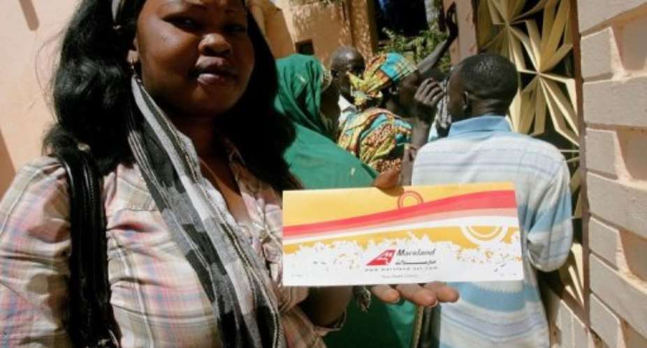A Southern Sudanese woman shows herplane ticket home as she waits for her travel documents.  By Ashraf Shazly (AFP/File)