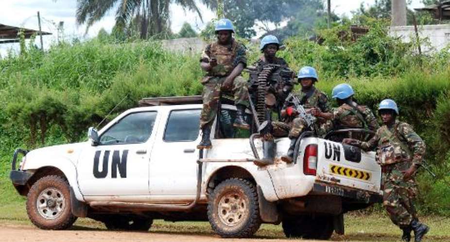 Blue helmet members of MONUSCO sit on the back of a UN pick-up truck on October 23, 2014 in Beni.  By Alain Wandimoyi AFPFile