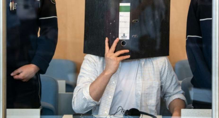 Defendant Sief Allah H. holds a folder in front of his face at the start of his trial on June 7, 2019 at a court in Duesseldorf, western Germany.  By Federico Gambarini dpaAFPFile