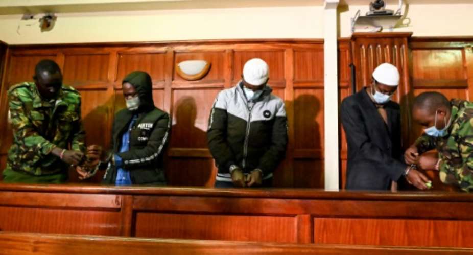 Defendants Hassan Hussein Mustafa left, Liban Abdullahi Omar centre and Mohamed Ahmed Abdi right have their handcuffs removed for Wednesday's verdict.  By Simon MAINA AFP