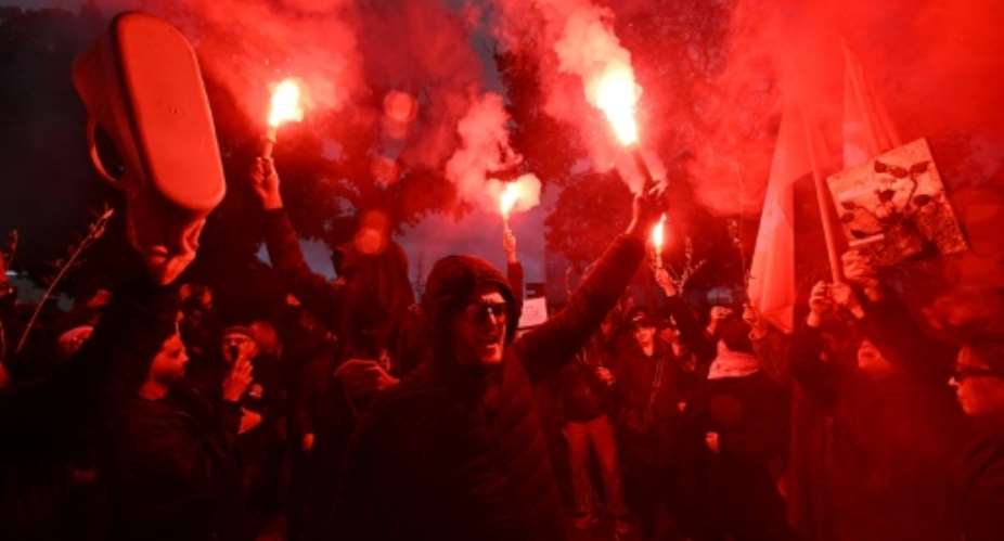 Demonstrators burn flares as they protest in Tunis.  By FETHI BELAID (AFP)