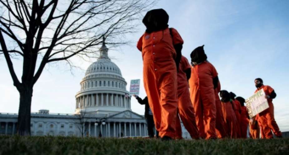 Demonstrators dressed in Guantanamo Bay prisoner uniforms march past Capitol Hill in Washington, DC, on January 9, 2020.  By Brendan Smialowski AFPFile