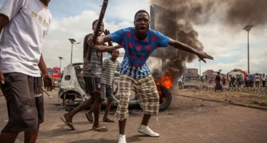 Demonstrators gather in front of a burning car during an opposition rally in Kinshasa.  By Eduardo Soteras AFPFile