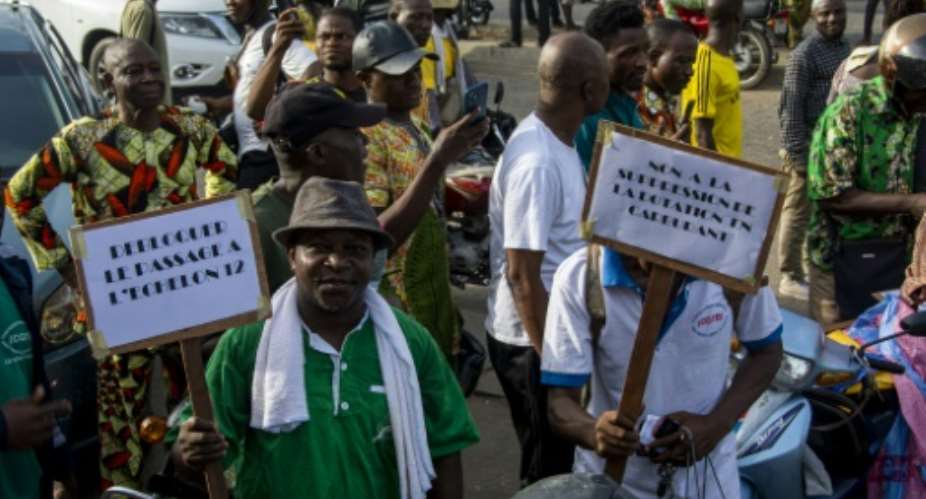 Demonstrators hold up placards during a march against the high cost of living in Cotonou, last April 27, 2024.  By Abadjaye Justin SODOGANDJI (AFP/File)