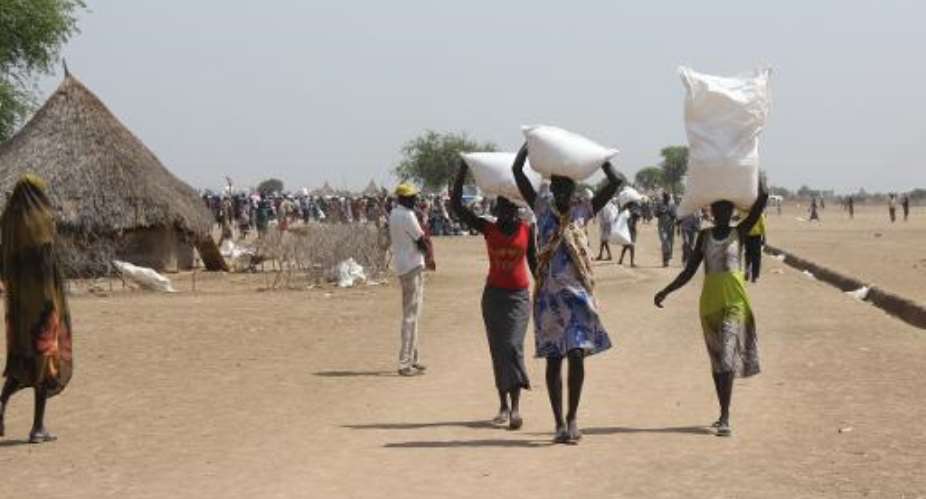 Women carry food items distributed by the World Food Program in Panyijar County of Unity State, South Sudan, on March 20, 2015.  By Waakhe Simon Wudu AFPFile