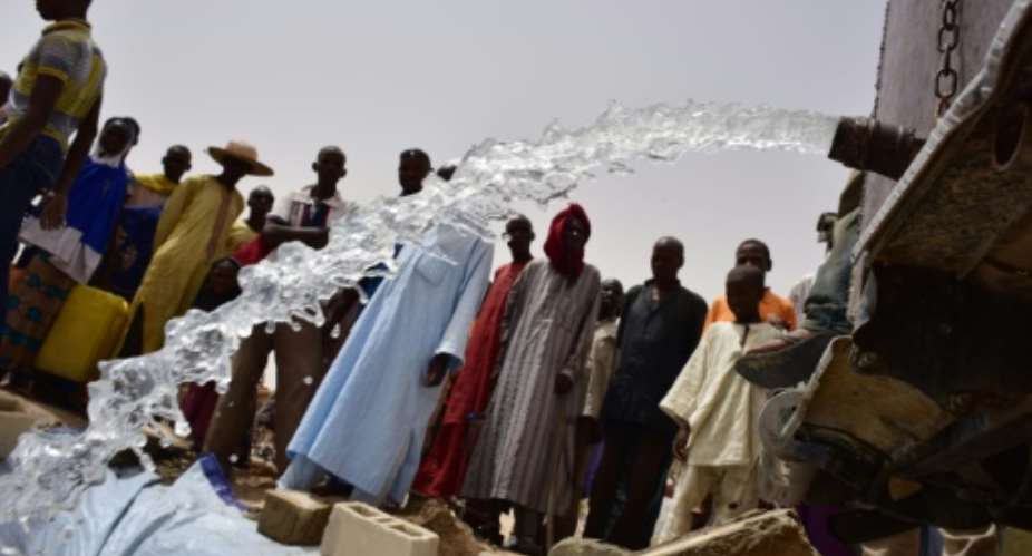 Displaced people look at the under construction water reservoir built by the UN system in a refugees camp of Kidjendi, around Diffa, southeastern Niger, on June 19, 2016.  By Issouf Sanogo AFPFile