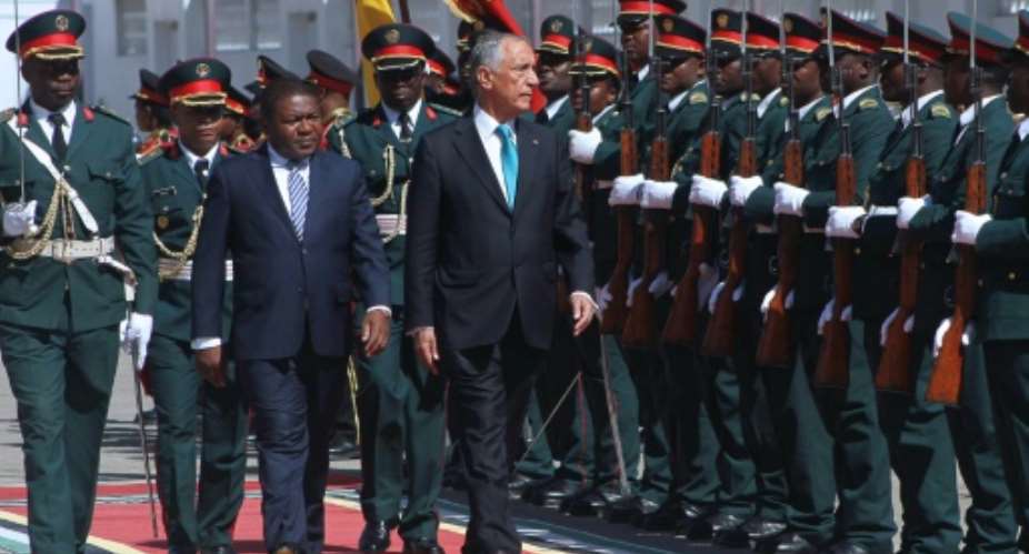 Mozambican President Filipe Nyusi L reviews an honour guard with his Portuguese counterpart Marcelo Rebelo de Sousa R during a welcoming ceremony in Maputo on May 4, 2016.  By Sergio Costa AFP
