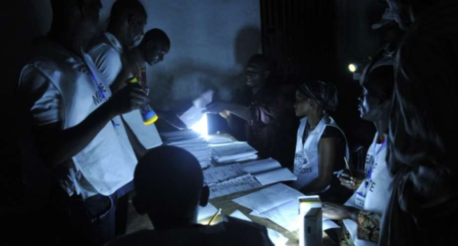 Election officials count votes at a polling station in Conakry on October 11, 2015.  By Cellou Binani AFP