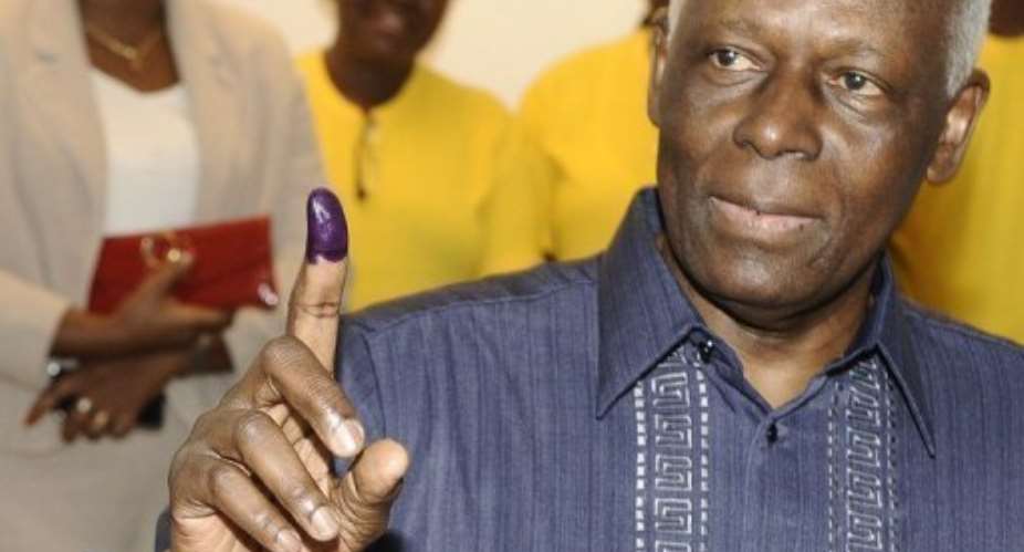 Angolan President Jose Eduardo Dos Santos shows his ink-marked finger as proof of his ballot cast at a polling station.  By Stephane de Sakutin AFP