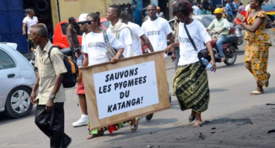 Demonstrators in Kinshasa take part in a rally on August 9, 2014 calling for an end to Pygmy discrimination from other communities, carrying a board reading Lets save the Pygmies from the Katanga province.  By Aziz Tutondele (AFP/File)
