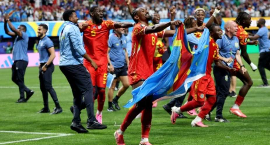 DR Congo players celebrate after the 3-1 win over Uzbekistan that sent them into the World Cup knockout rounds for the first time.  By Molly Darlington (GETTY IMAGES NORTH AMERICA/AFP)