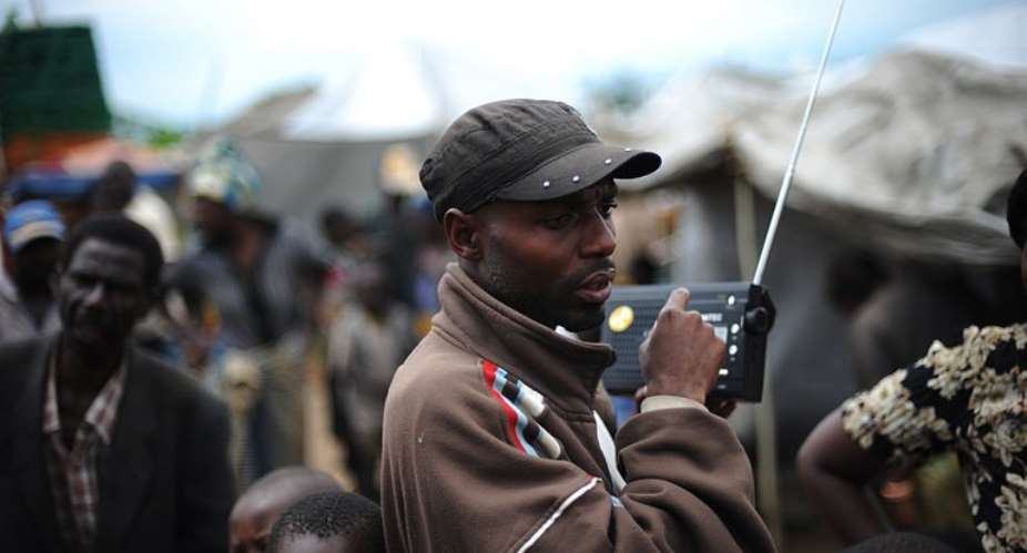 A man listens to news on the radio in the outskirts of the North Kivu town of Kiwanja in 2008.  By Roberto Schmidt (AFP/File)