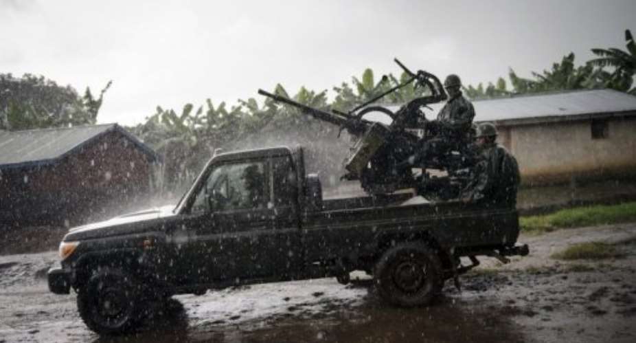 A truck of the Armed Forces of the Democratic Republic of the Congo leaves a firing position through a village in Jomba.  By Phil Moore (AFP/File)