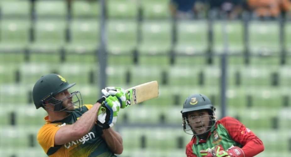 South Africa captain Faf du Plessis (L) plays a shot as Bangladesh wicketkeeper Mushfiqur Rahim looks on during the first T20 international at the Sher-e-Bangla National Cricket Stadium in Dhaka on July 5, 2015.  By Munir Uz Zaman (AFP)