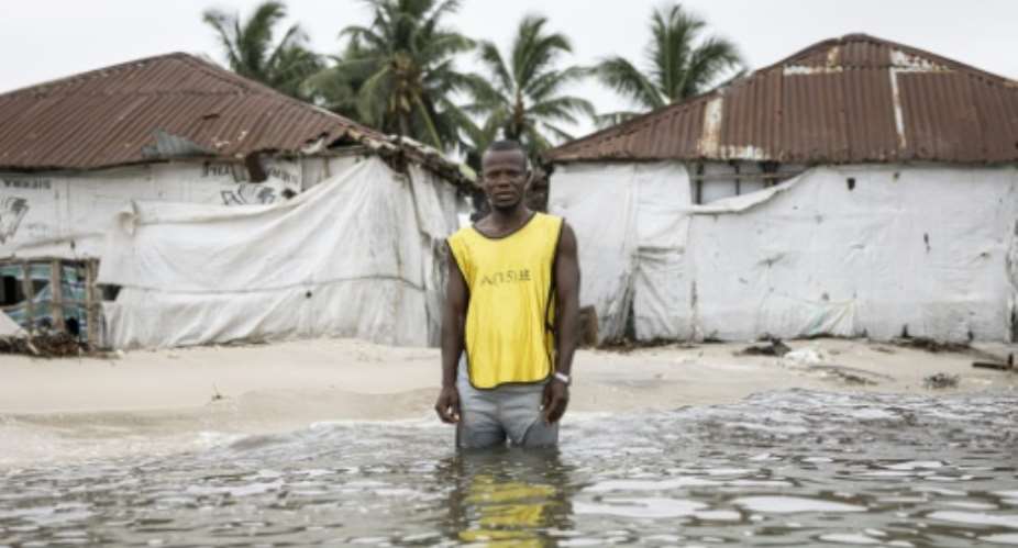 During high tide on Nyangai island, Hassan Kargbo shows AFP where buildings used to stand.  By PATRICK MEINHARDT (AFP)