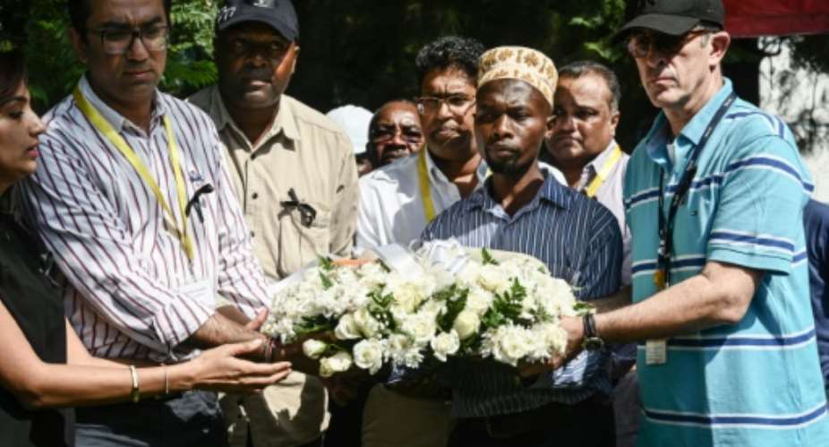 DusitD2 hotel General Manager Michael Metaxas R, a survivor, placed a wreath with other staff at the gate of the complex in Nairobi where 21 people were killed.  By Simon MAINA AFP