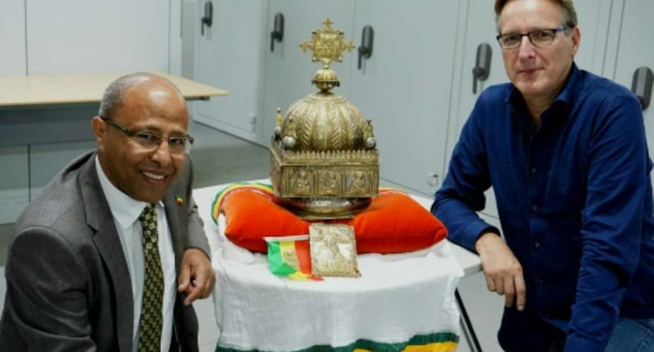 Dutch-Ethiopian Sirak Asfaw, left, and art detective Arthur Brand pose with the coveted crown at a high-security facility in the Netherlands in September last year.  By Jan HENNOP AFP