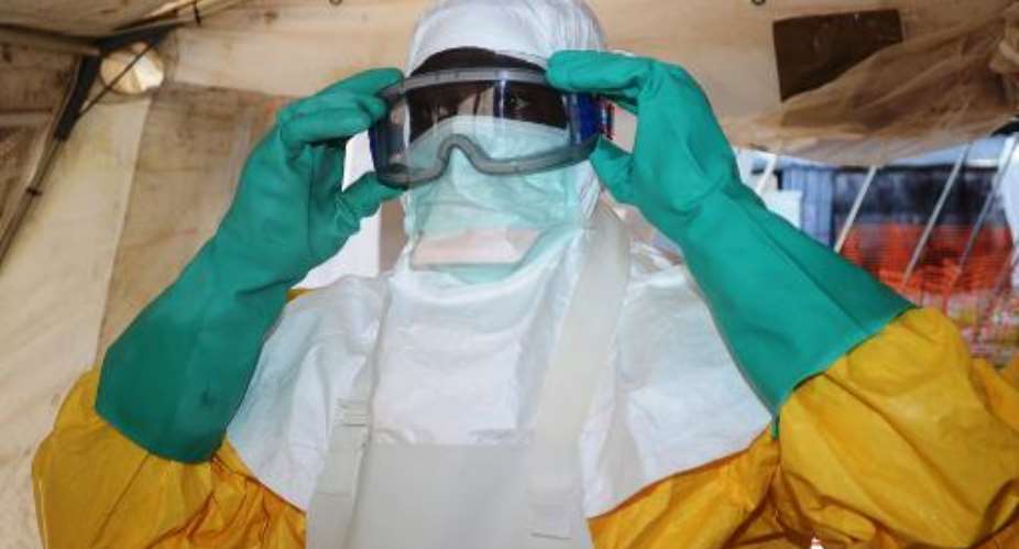 A health worker with Doctors Without Borders MSF puts on protective gear at an Ebola isolation ward in Conakry, on June 28, 2014.  By Cellou Binani AFPFile