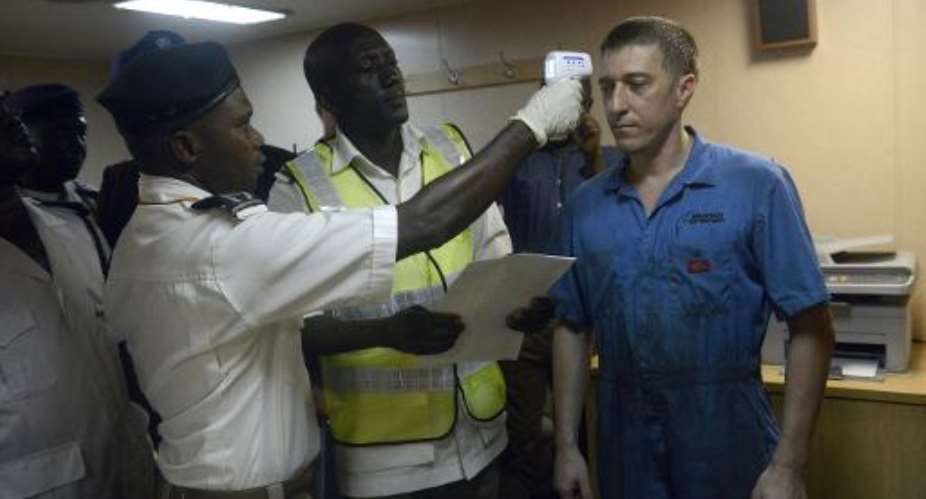 Health officials take the body temperature of a Ukrainian sailor at the Apapa Sea Port, in Lagos, Nigeria, on September 29, 2014.  By Pius Utomi Ekpei AFP