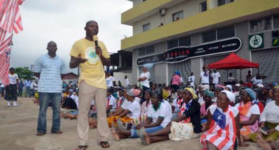A man addresses members of Women in Peace Building Network WIPNET who came to pray to drive away Ebola from Liberia at a location not far from the residence of the president in Monrovia, on August 6, 2014.  By Zoom Dosso AFP
