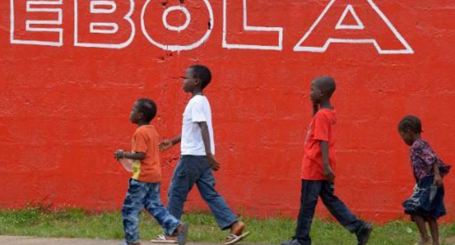 Children walk past a slogan painted on a wall reading Ebola in Monrovia on August 31, 2014.  By Dominique Faget AFPFile
