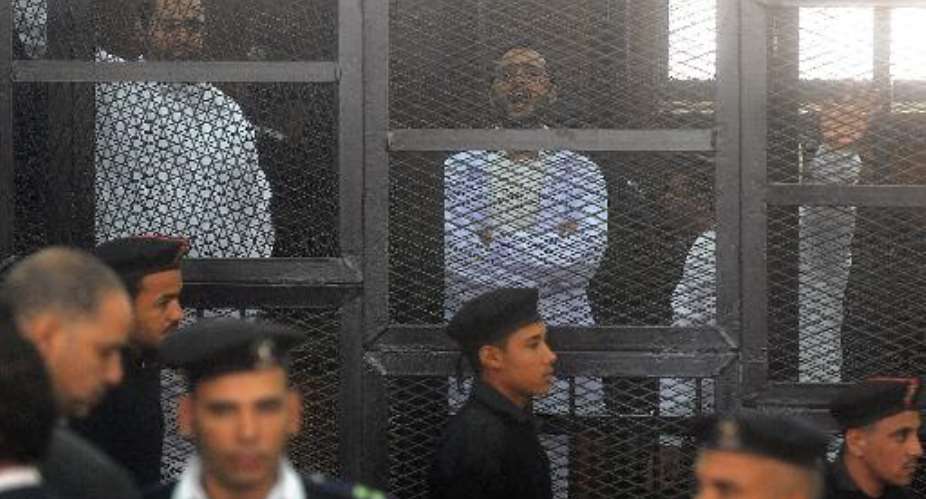 Egyptian activicts Mohamed Adel L, Ahmed Douma C and Ahmed Maher R stand in the accused dock during their trial on December 22, 2013 in the capital Cairo.  By  AFPFile