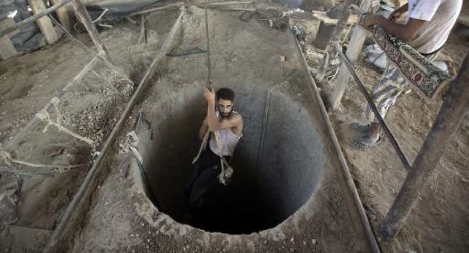 A Palestinian man is lowered into a smuggling tunnel beneath the Gaza-Egypt border, in the southern Gaza Strip, on September 11, 2013.  By Mahmud Hams AFPFile