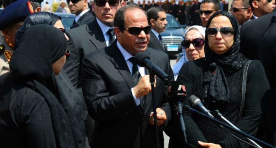 A picture released by the Egyptian Presidency on June 30, 2015, shows President Sisi C talking to media as he stands with the family of Egyptian state prosecutor, Hisham Barakat during his funeral in Cairo.  By  Egyptian PresidencyAFPFile
