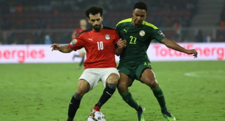 Egypt captain Mohamed Salah L tussles for possession  with Senegal forward Mame Thiam during the Africa Cup of Nations final in Yaounde on February 6, 2022..  By Daniel BELOUMOU OLOMO AFP