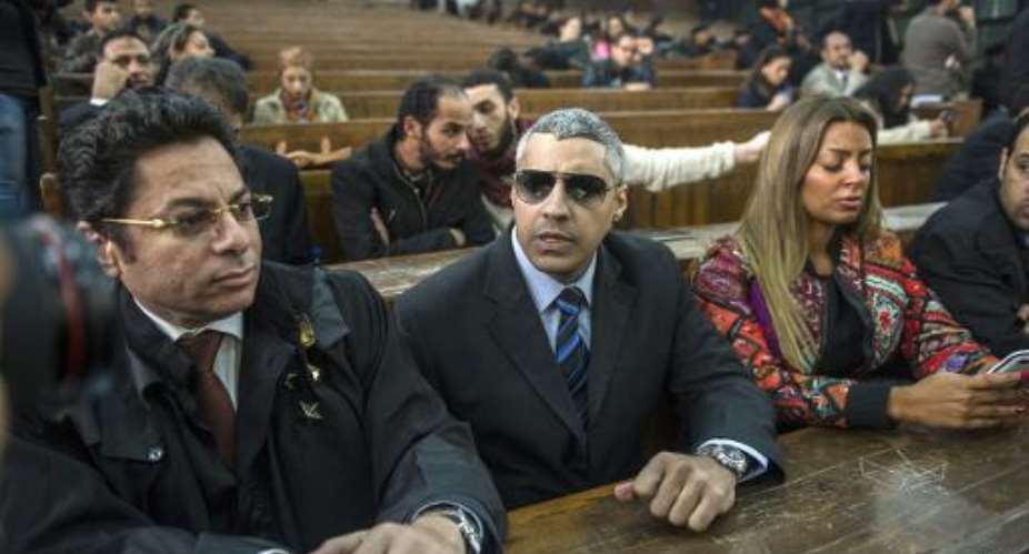 Al-Jazeera's Egyptian-Canadian reporter Mohamed Fadel Fahmy C and his lawyer Khaled Abou Bakr L attend the trial at the Tora prison in Cairo on February 23, 2015.  By Khaled Desouki AFPFile
