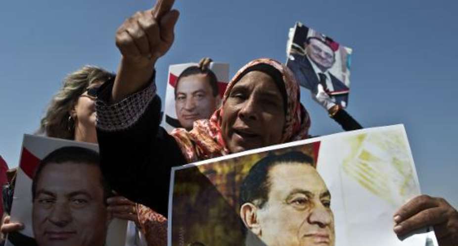 A supporter holds a portrait of Egyptian toppled president Hosni Mubarak on September 14, 2013 in Cairo.  By Khaled Desouki AFPFile