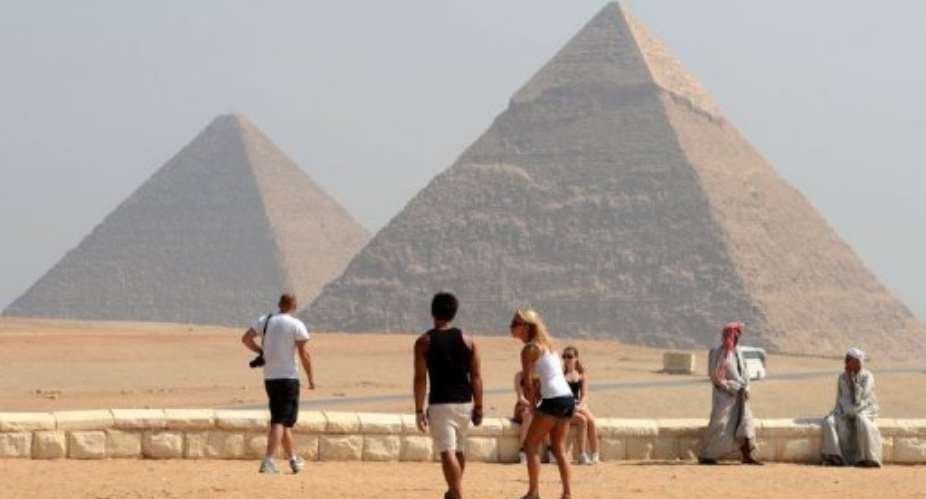 Foreign tourists visit the Giza pyramids, south of the Egyptian capital Cairo on October 1, 2012.  By Khaled Desouki AFPFile