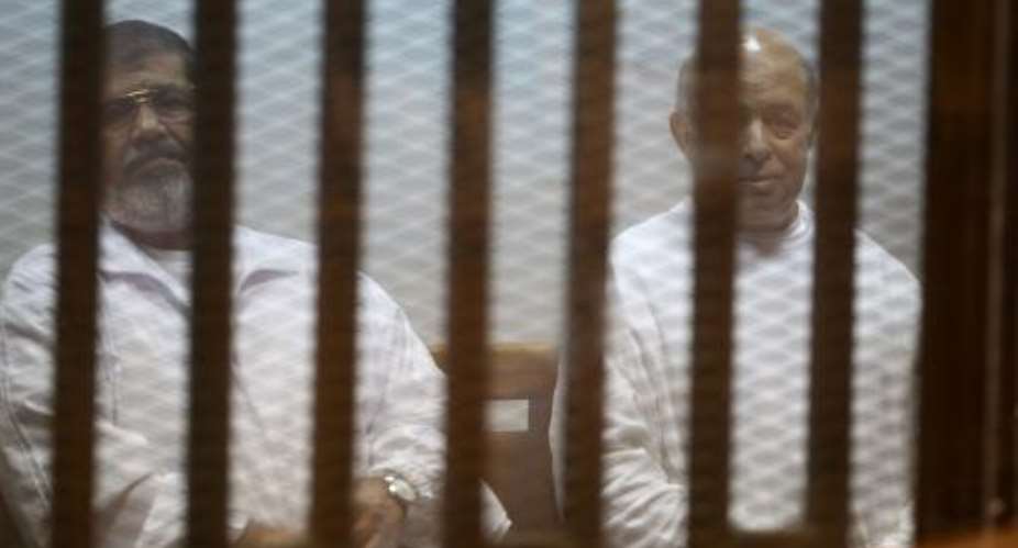 Egypt's deposed president Mohamed Morsi left and his former chief of staff Refaa al-Tahtawi sit inside the defendants' cage during their 2014 trial in Cairo.  By Ahmed Ramadan AFPFile