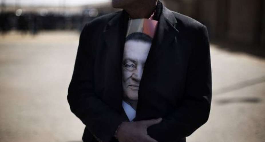 A supporter of ousted Egyptian president Hosni Mubarak outside the court in Cairo.  By Marco Longari AFP