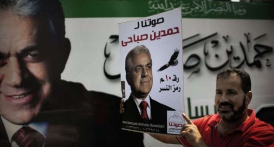 A supporter of Egyptian presidential candidate Hamdin Sabahi holds a campaign poster.  By Marco Longari (AFP)