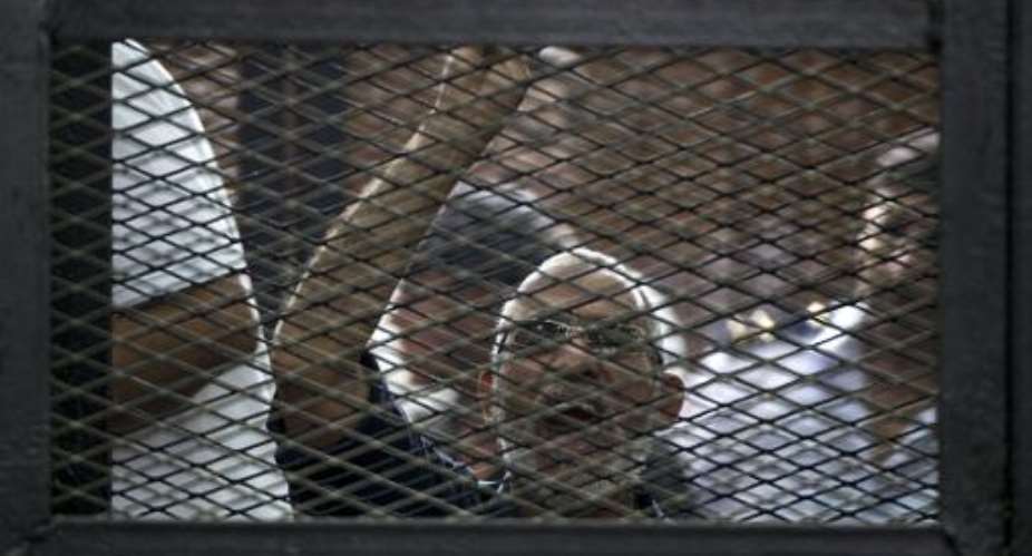 Egyptian Muslim Brotherhood leader Mohamed Badie gestures as he shouts from inside the defendants cage during his trial in the capital Cairo on June 7, 2014.  By Khaled Desouki AFPFile