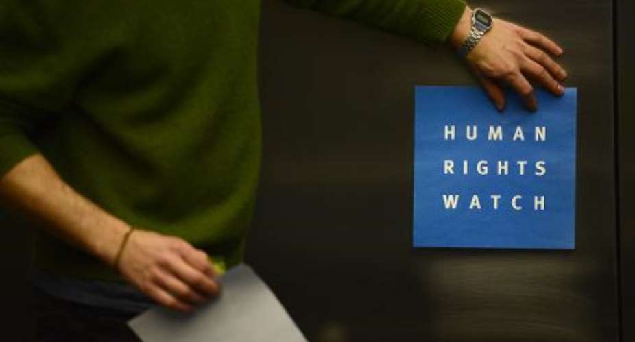 A man puts a logo of US-based rights group Human Rights Watch on the wall before a press conference on January 21, 2014 in Berlin.  By John MacDougall AFPFile