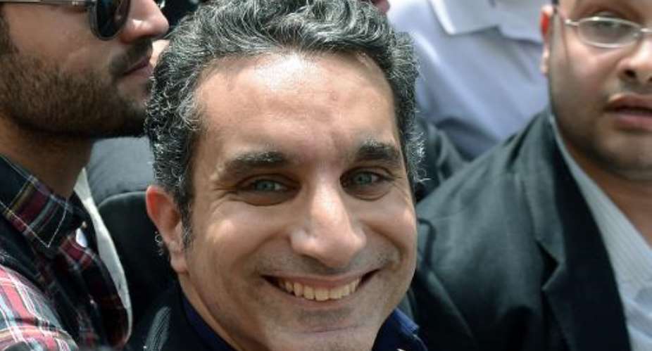 Egyptian satirist and television host Bassem Youssef is surrounded by his supporters upon his arrival at the public prosecutor's office in the high court in Cairo, on March 31, 2013.  By Khaled Desouki AFPFile