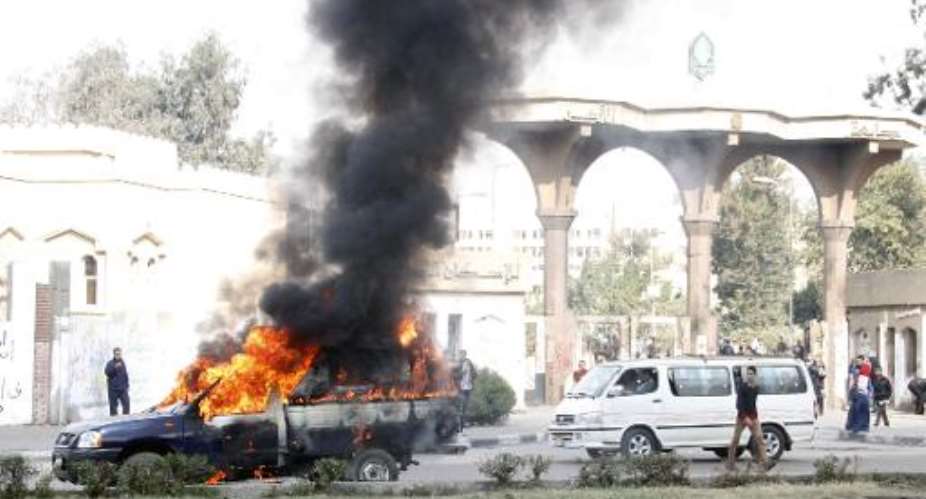 A police vehicle burns outside Al-Azhar university after it was torched by students on January 4, 2014.  By Khaled Kamel AFPFile