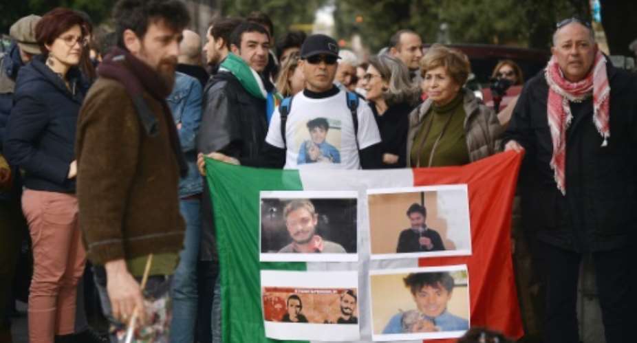 Protesters hold an Italian flag with photos of Giulio Regeni, during a demonstration in front of the Egyptian embassy in Rome, on February 25, 2016.  By Filippo Monteforte AFPFile