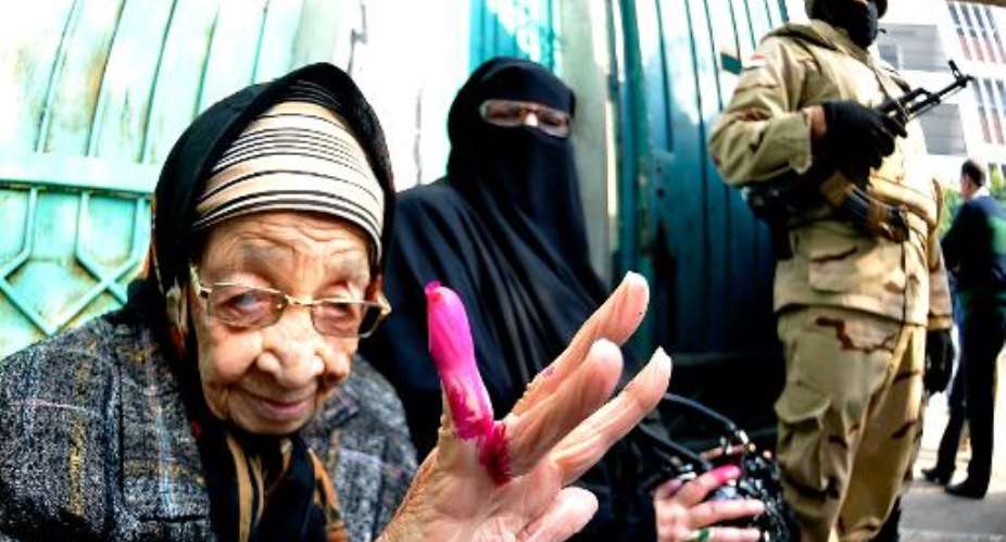 An Egyptian woman shows her ink-stained finger after casting her vote at a polling station during the second day of voting on a new constitution on January 15, 2014 in the northern port city of Alexandria.  By  AFPFile