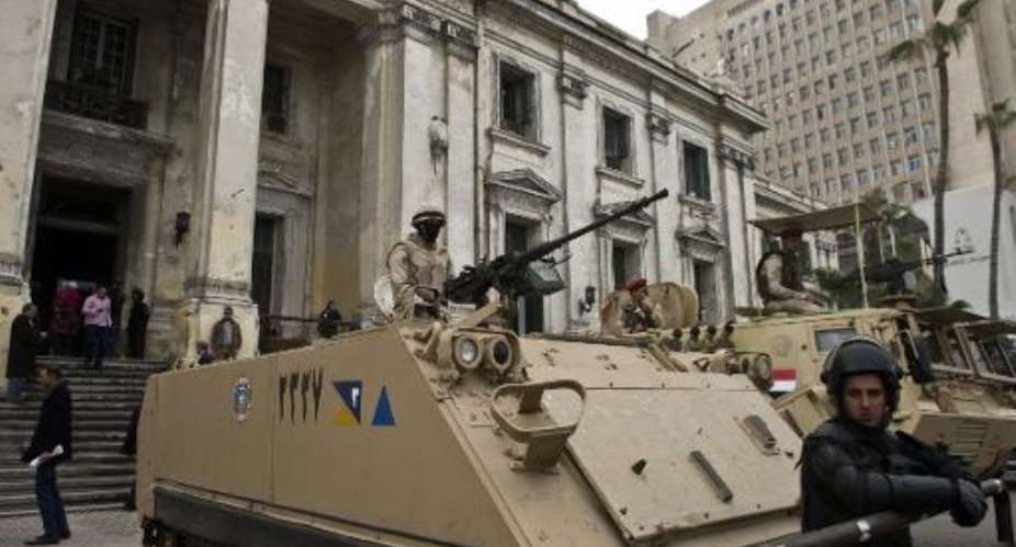 Egyptian soldiers and police stand guard with armoured personnel carriers APC outside the criminal court in the Mediterranean city of Alexandria on March 3, 2014.  By Khaled Desouki AFPFile