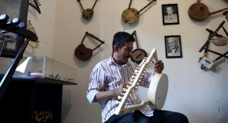Egyptian craftsman Mohamed Ghaly adds the finishing touches on a semsemia that he made at the Canal 20 cultural museum in Port Said which he founded to pass on the musical heritage to a new generation.  By Khaled DESOUKI AFP