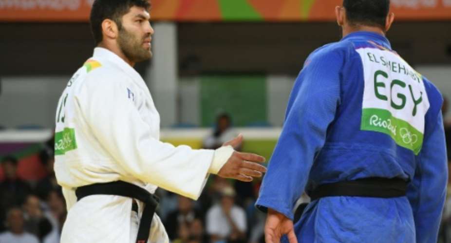 Israel's Or Sasson white holds out his hand to Egypt's Islam El Shehaby after their men's +100kg judo contest at the Rio 2016 Olympic Games in Rio on August 12, 2016.  By Toshifumi Kitamura AFP