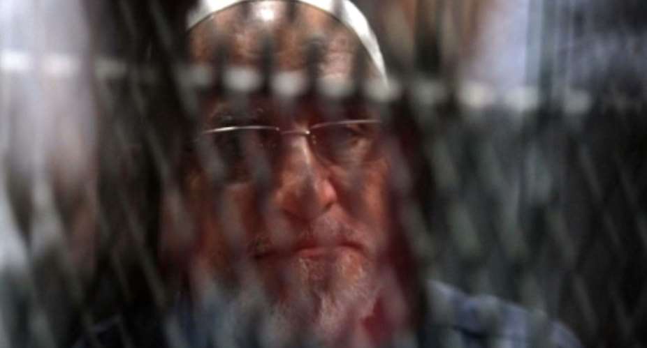Egyptian Muslim Brotherhood Supreme Guide Mohamed Badie is seen behind bars during a hearing for him and other Brotherhood members on charges of espionage, as the country's crackdown on the Islamist group continues.  By Khaled KAMEL AFPFile