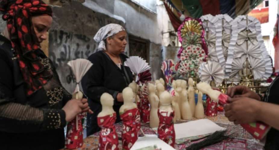 Egyptian women decorate traditional sugar statuettes in the capital Cairo for Al Mawlid Al Nabawi celebrations.  By Mohamed el-Shahed, Mohamed el-Shahed AFP