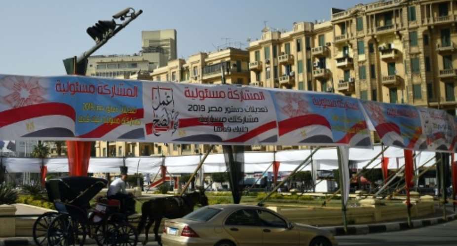 Egyptians pass under banners reading in Arabic Do what is right, and Participation is your responsibility, urging voters to participate in a referendum on constitutional amendments.  By Mohamed el-Shahed AFP