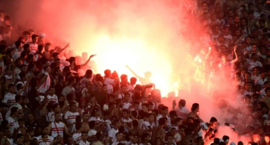 Egypt's Zamalek fans fire flares during the football match between Egypt's Zamalek and Al Ahli Tripoli during their African Champions League CAF group stage football match, at Borg el-Arab Stadium near Alexandria on July 9, 2017.  By KHALED DESOUKI AFPFile