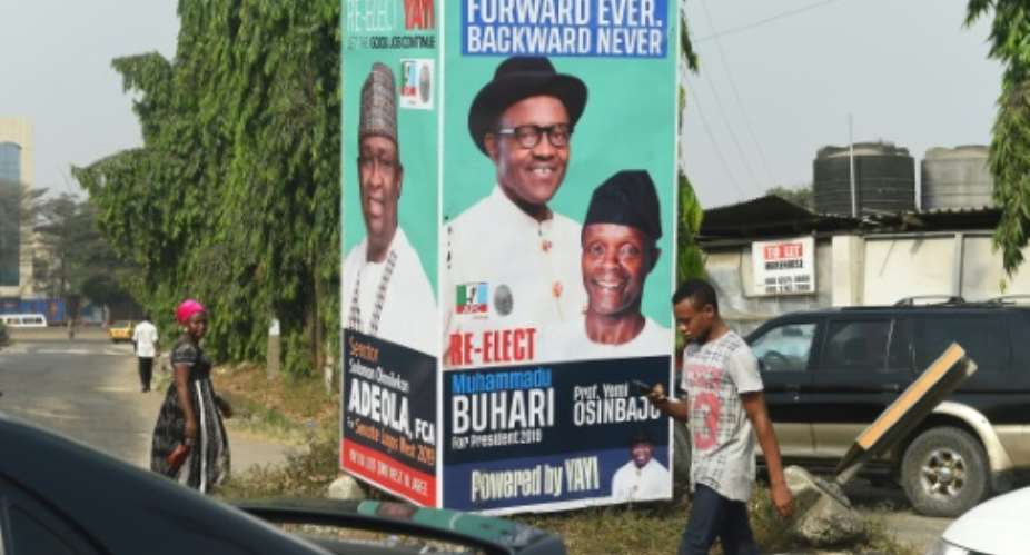 Election time: A campaign poster in Lagos for President Muhammadu Buhari and Vice President Yemi Osinbajo, contending next month's polls.  By PIUS UTOMI EKPEI AFP